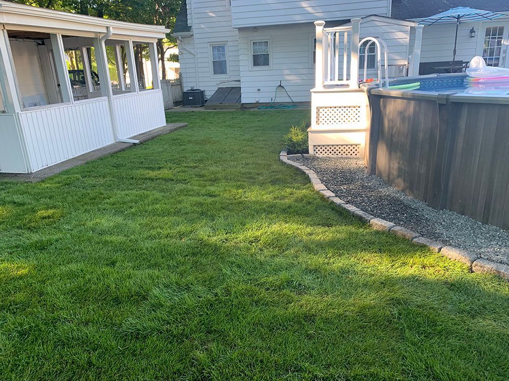 A backyard featuring a pool and a lush green lawn, perfect for relaxation and outdoor activities.