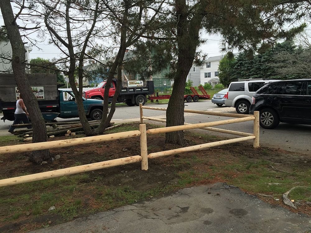 A vehicle parked alongside a wooden fence.