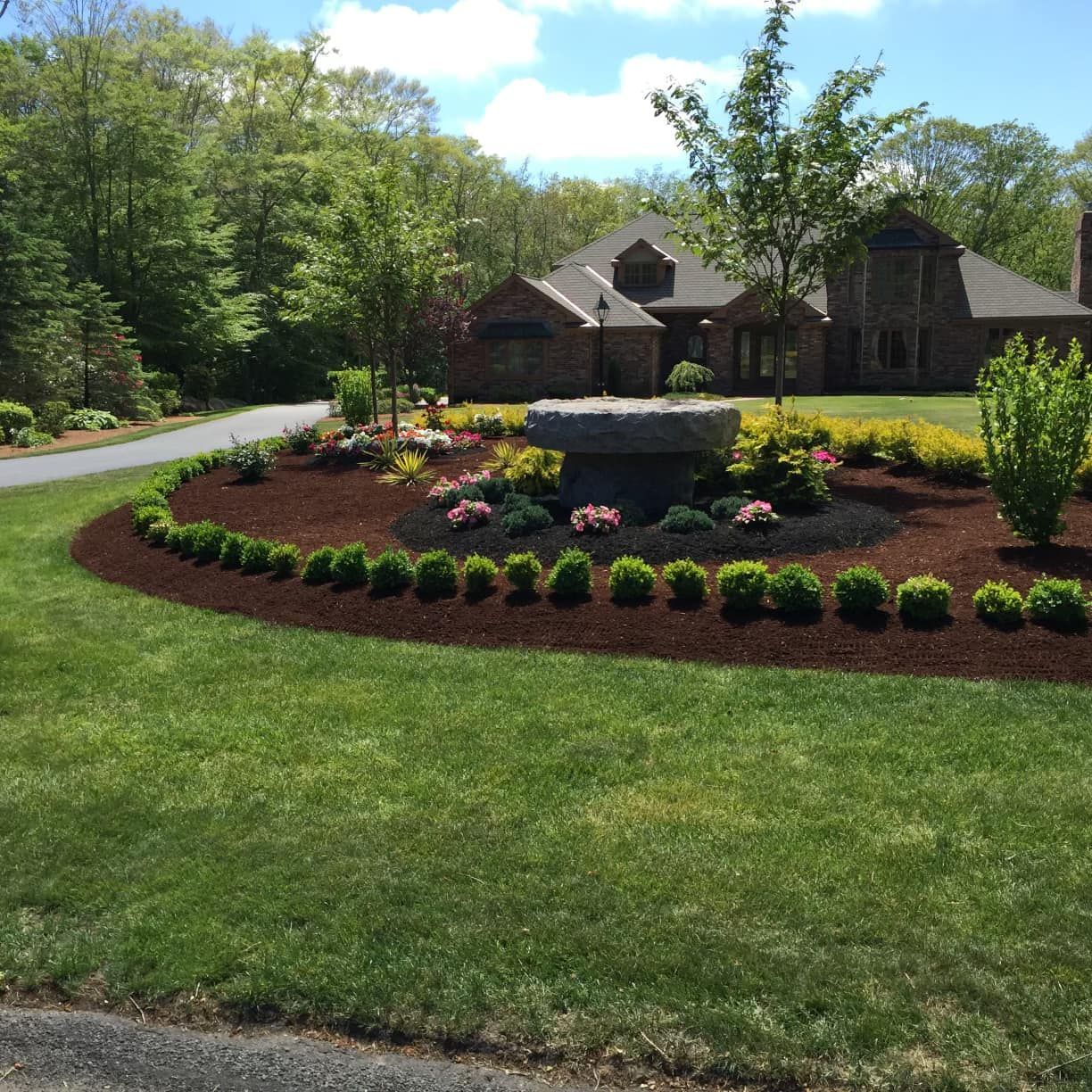a large house with a circular garden in front of it