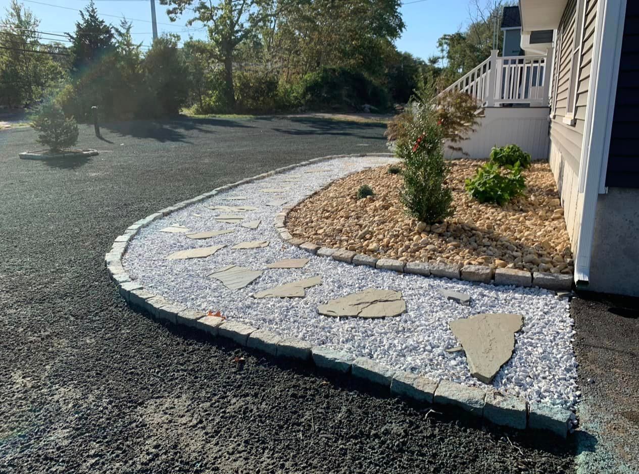 a walkway leading to a house with gravel and rocks