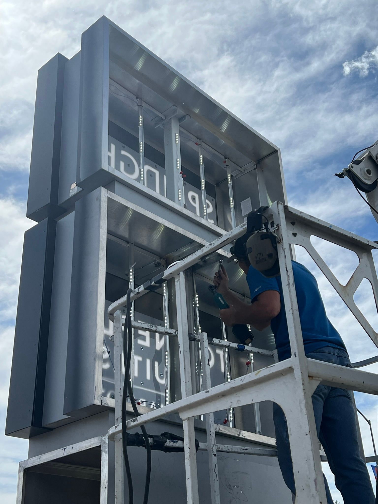 A man in a blue shirt is working on a large building.