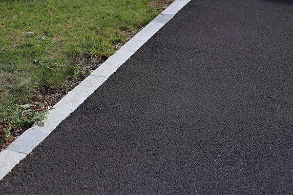 Asphalt path with white edge line beside grass