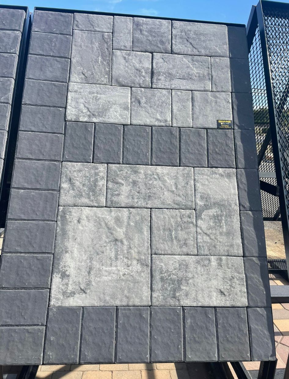 Gray and dark charcoal stone wall with a patterned rectangular inset under blue sky