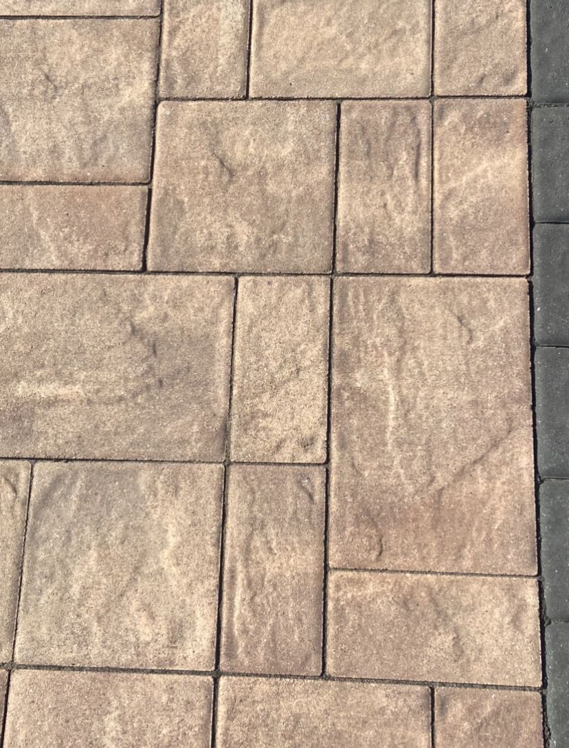 Close-up of tan stamped concrete pavers with a stone tile pattern and dark grout lines