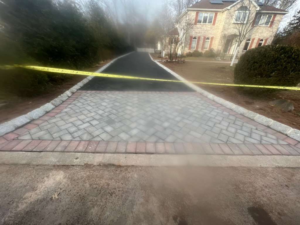 Cordoned-off cobblestone path leading to houses, blocked by yellow caution tape in a residential area