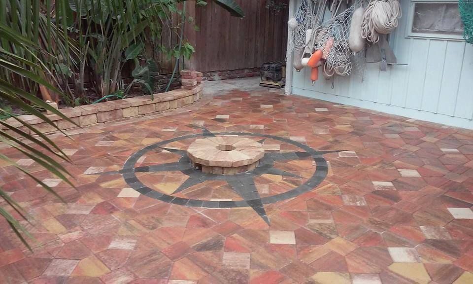 Brick patio with compass rose design and small brick fire pit.