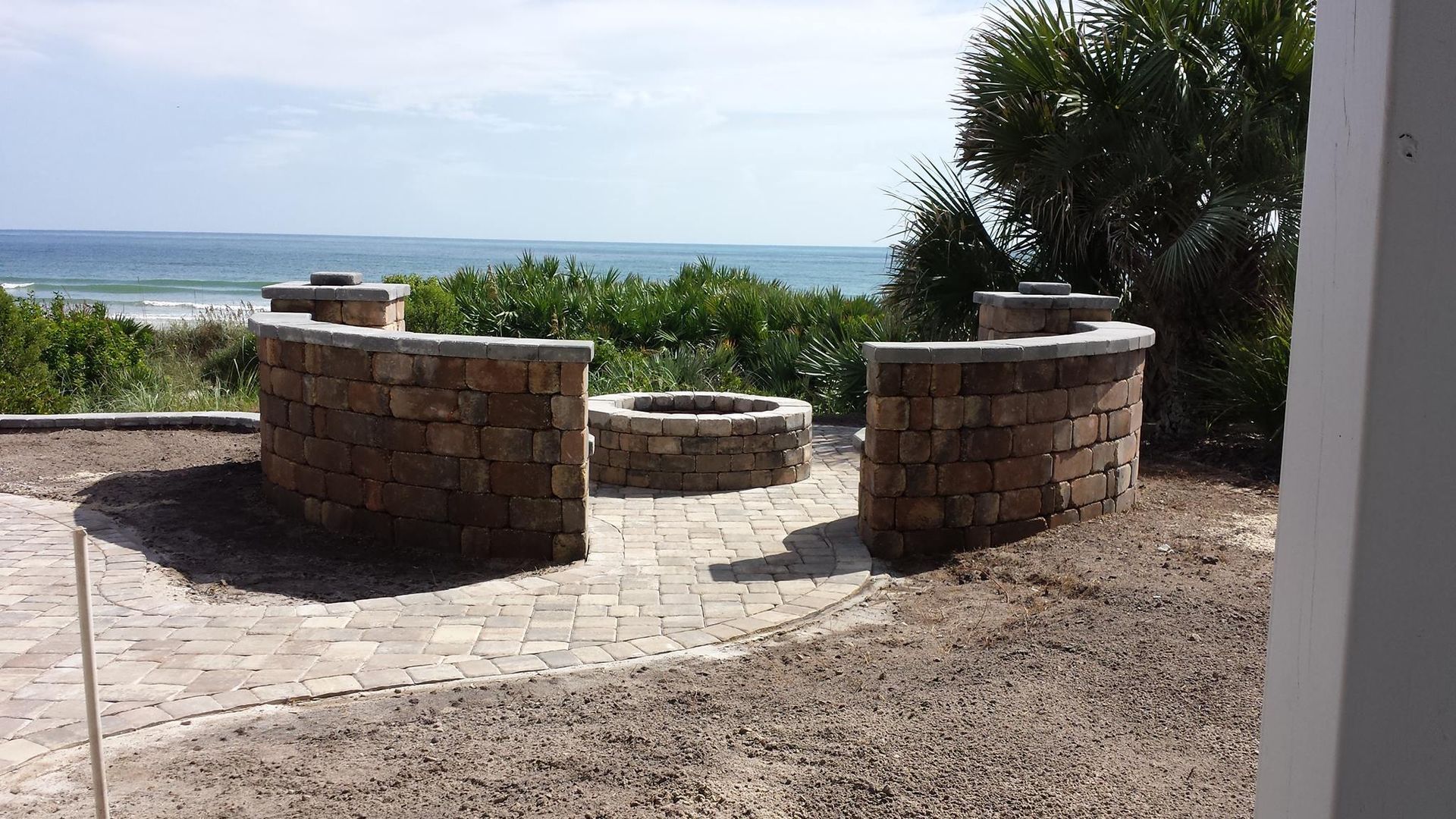 Stone fire pit and seating area overlooking the ocean.