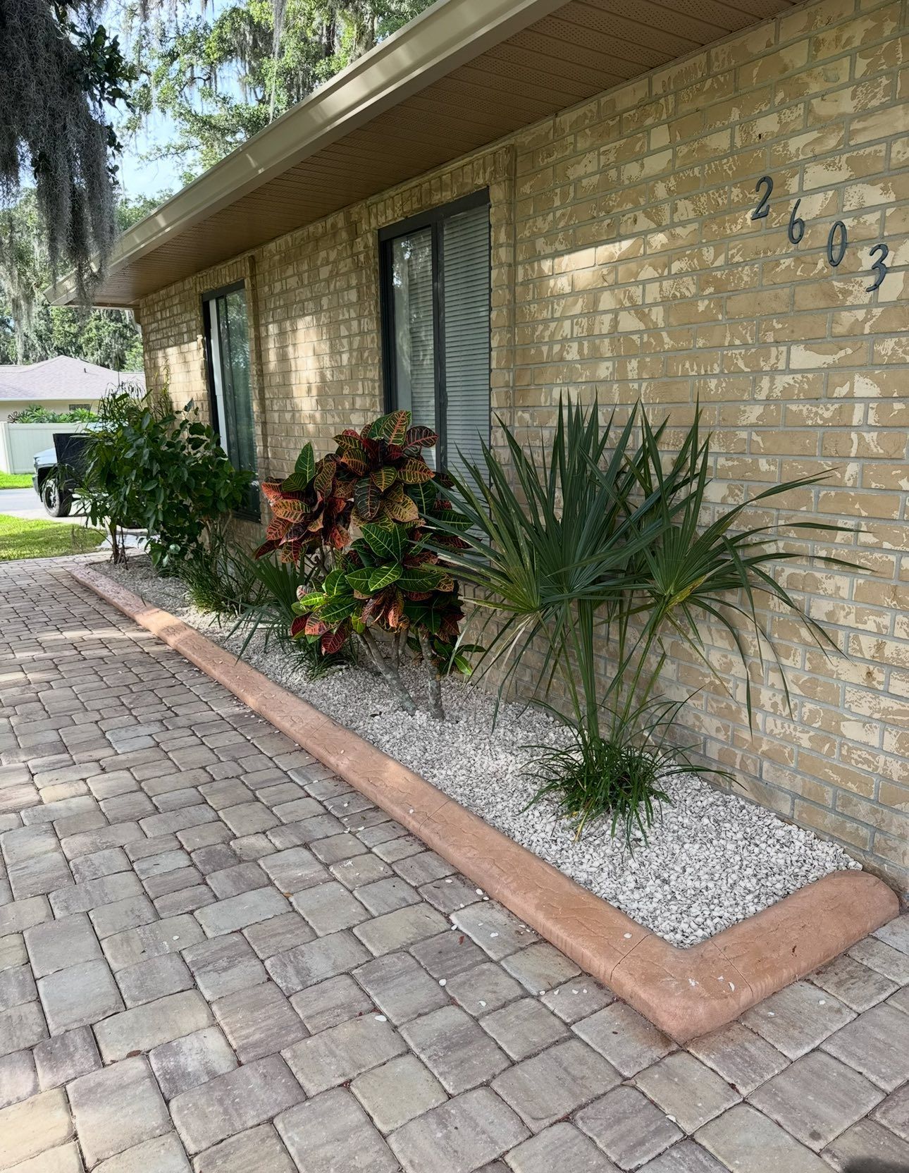 Brick house with a small stone garden bed in front.