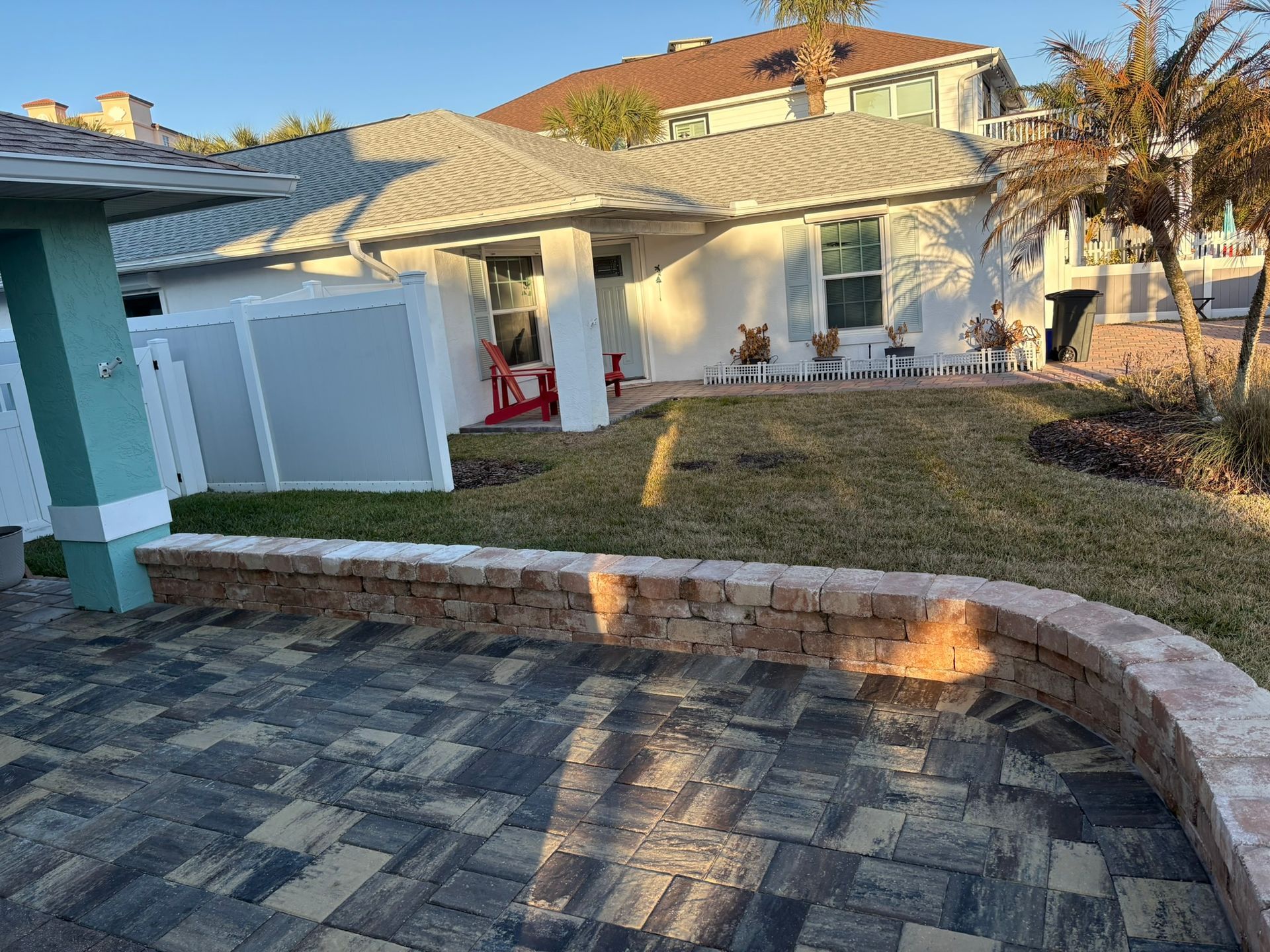 Suburban house with stone driveway, white garage, and front yard in sunlight