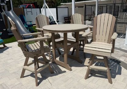 Outdoor patio set with round table and four wooden chairs in sunlight