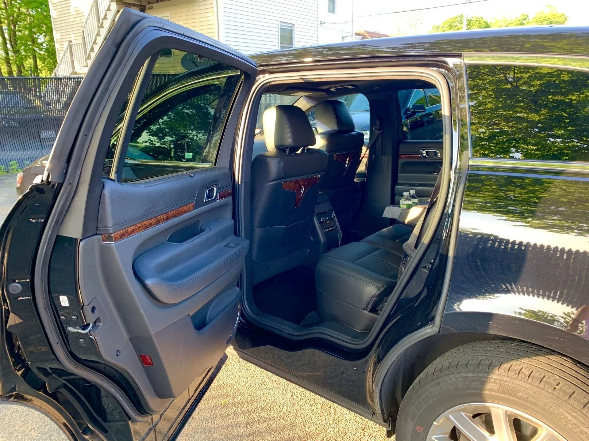 Black SUV with rear door open, revealing dark interior and seats.