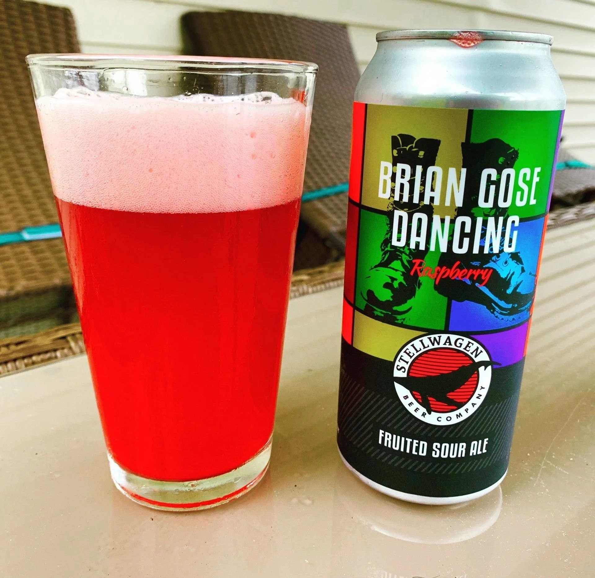 A glass of bright red beer and a can labeled