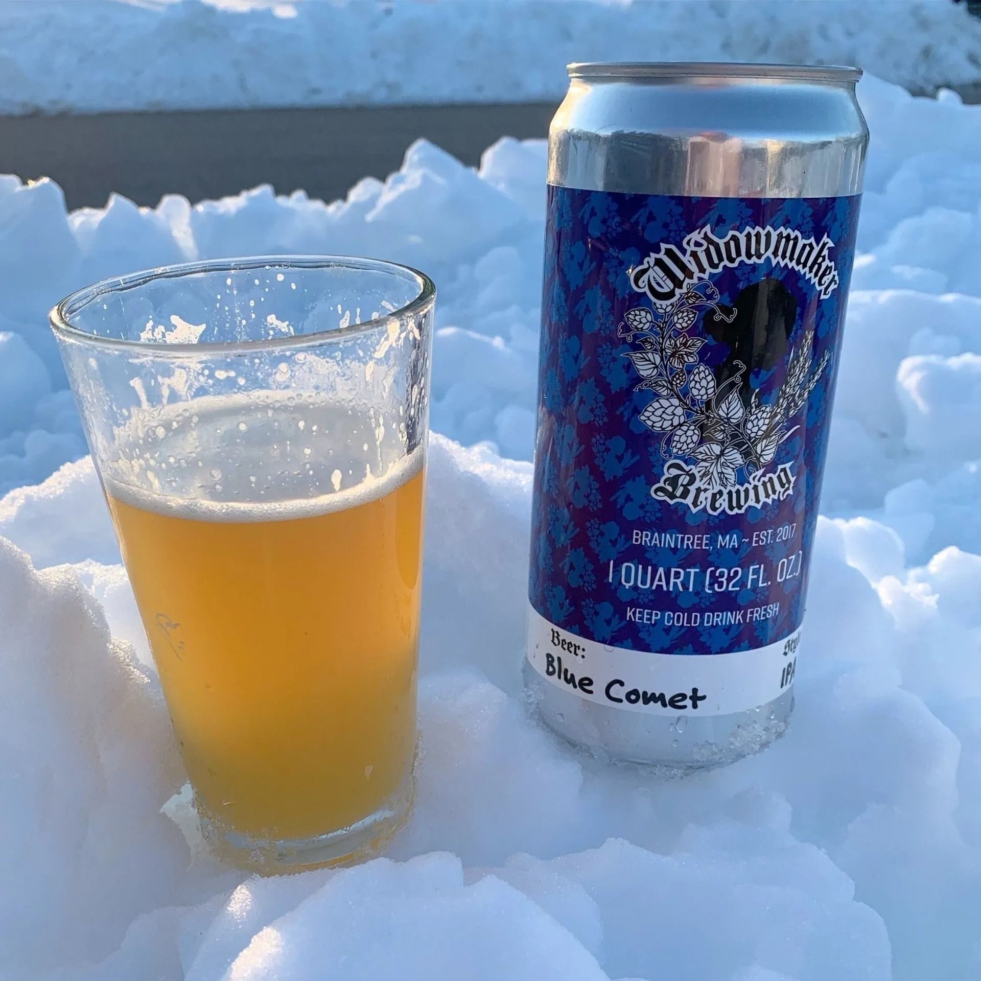 Glass of beer and can on snow;