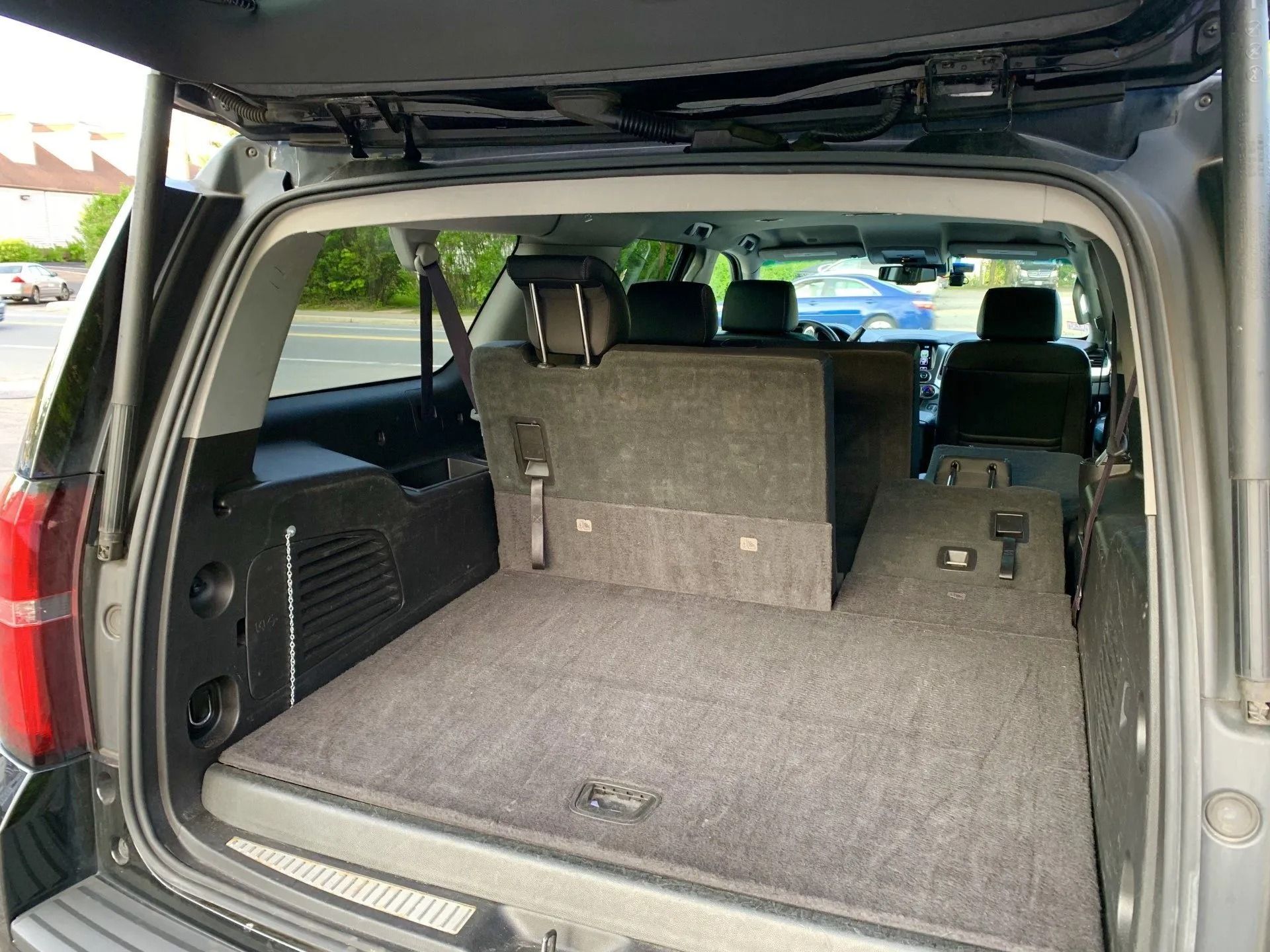Rear view of a gray SUV cargo area with seats folded down, covered in gray carpet.