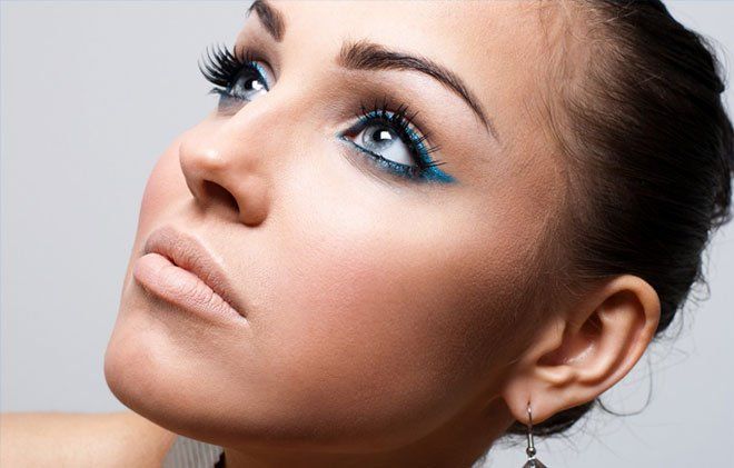 Woman with blue eye liner looking up