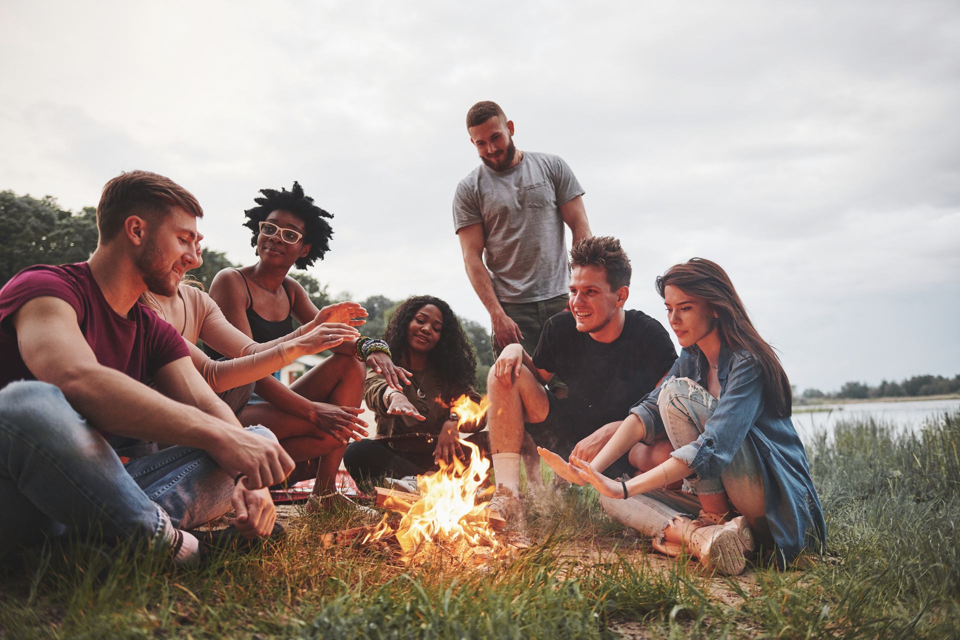 Group of friends around a campfire in the summertime