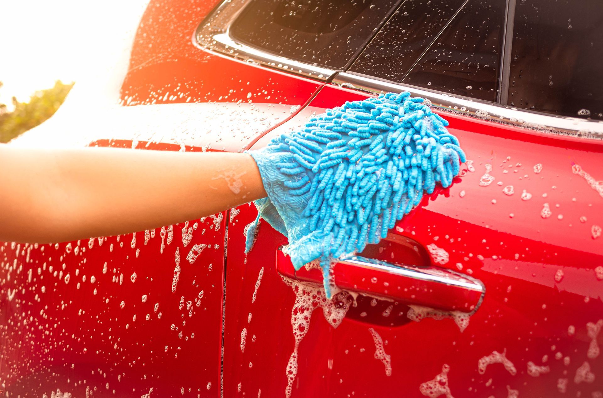 Person washing a red car