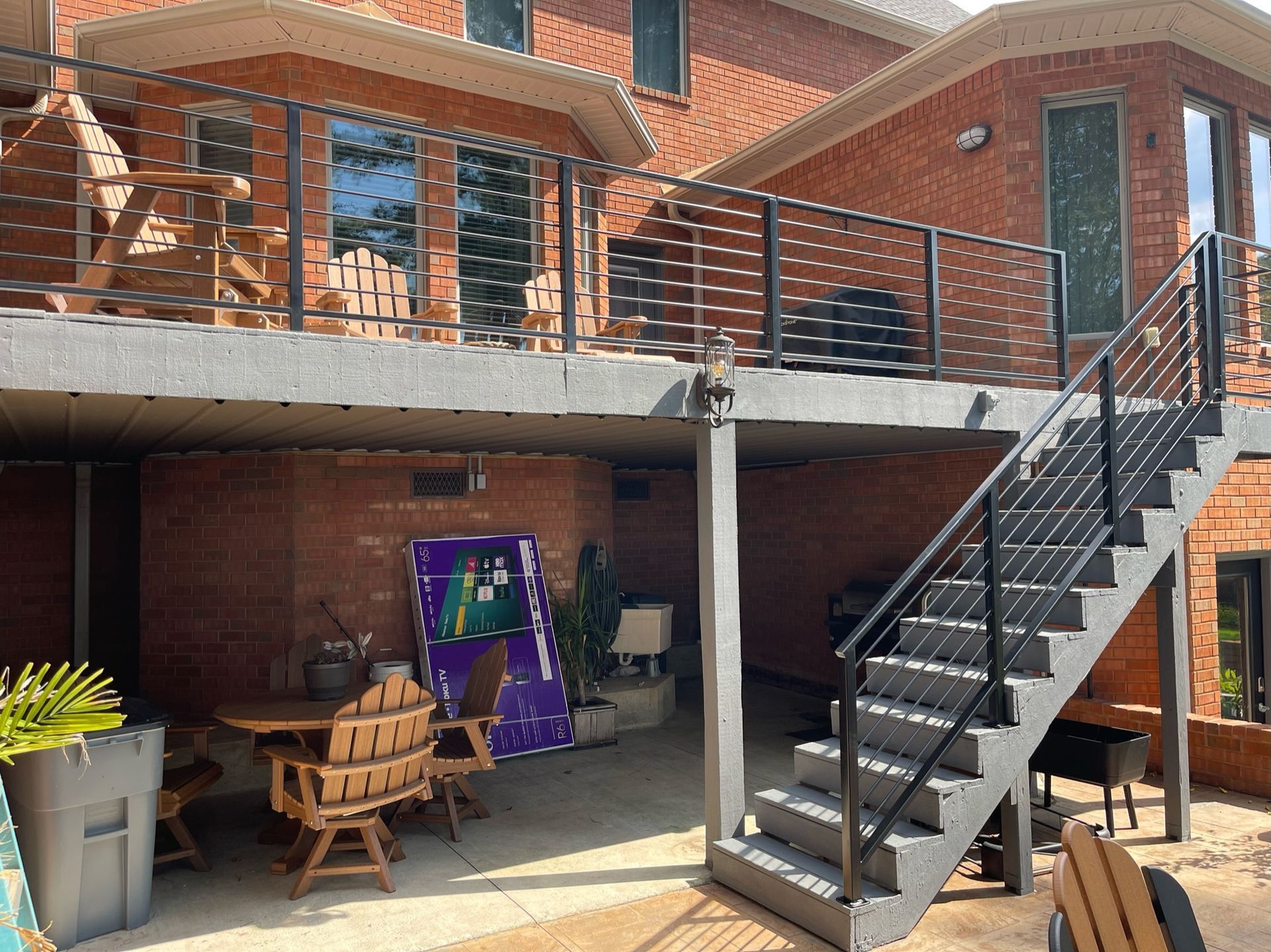 a brick house with a large deck and stairs leading up to it