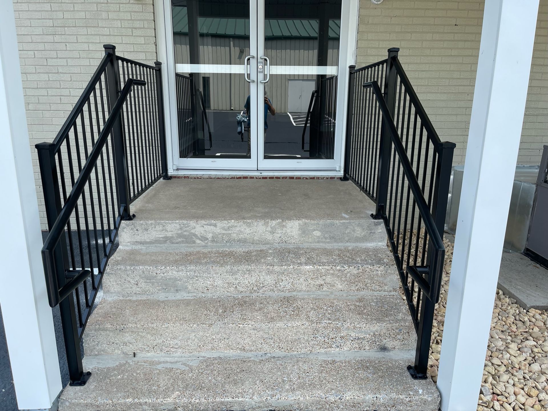 a set of stairs leading up to a door with a wrought iron railing
