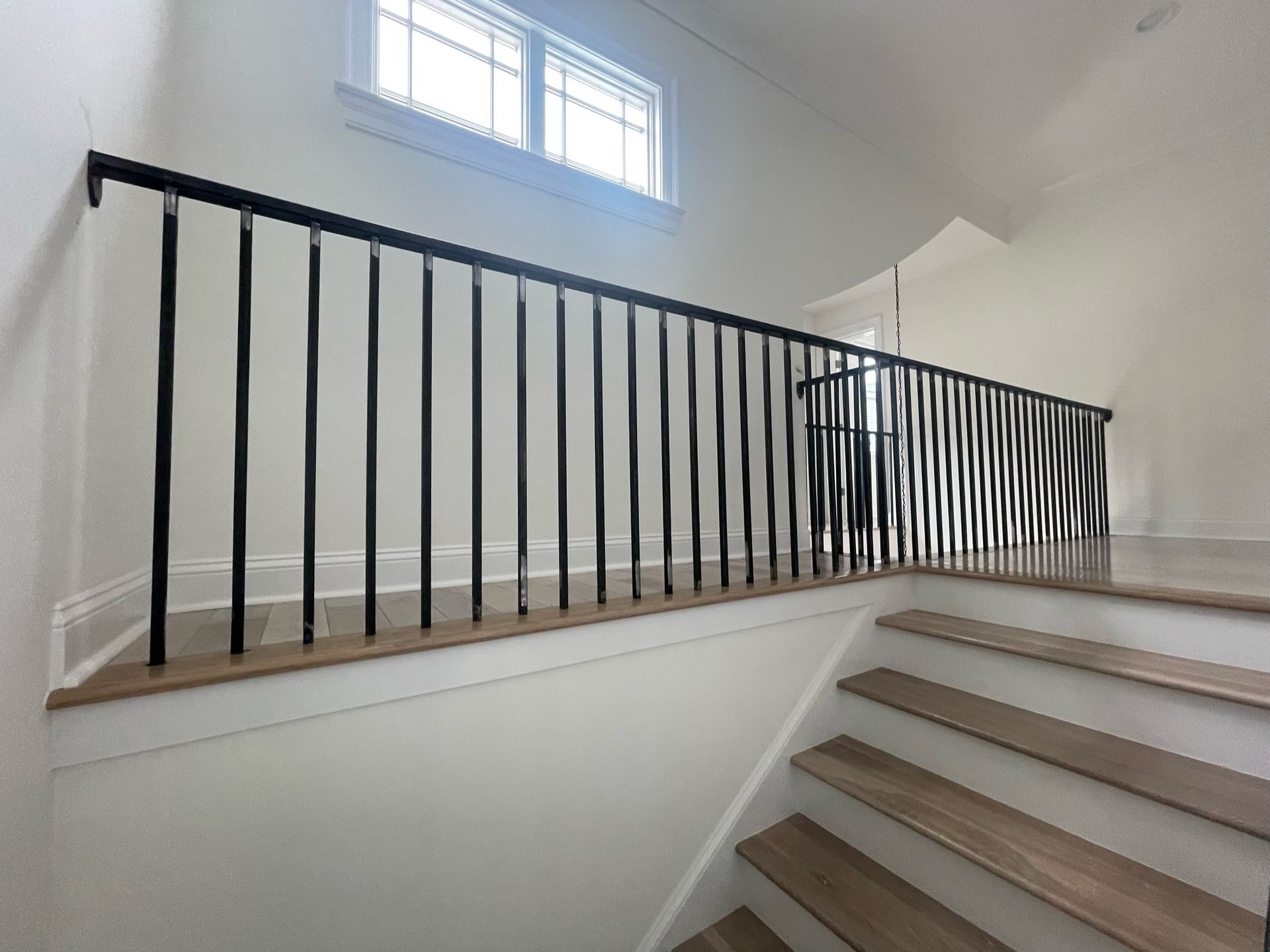 a staircase with a black railing and wooden steps in a house