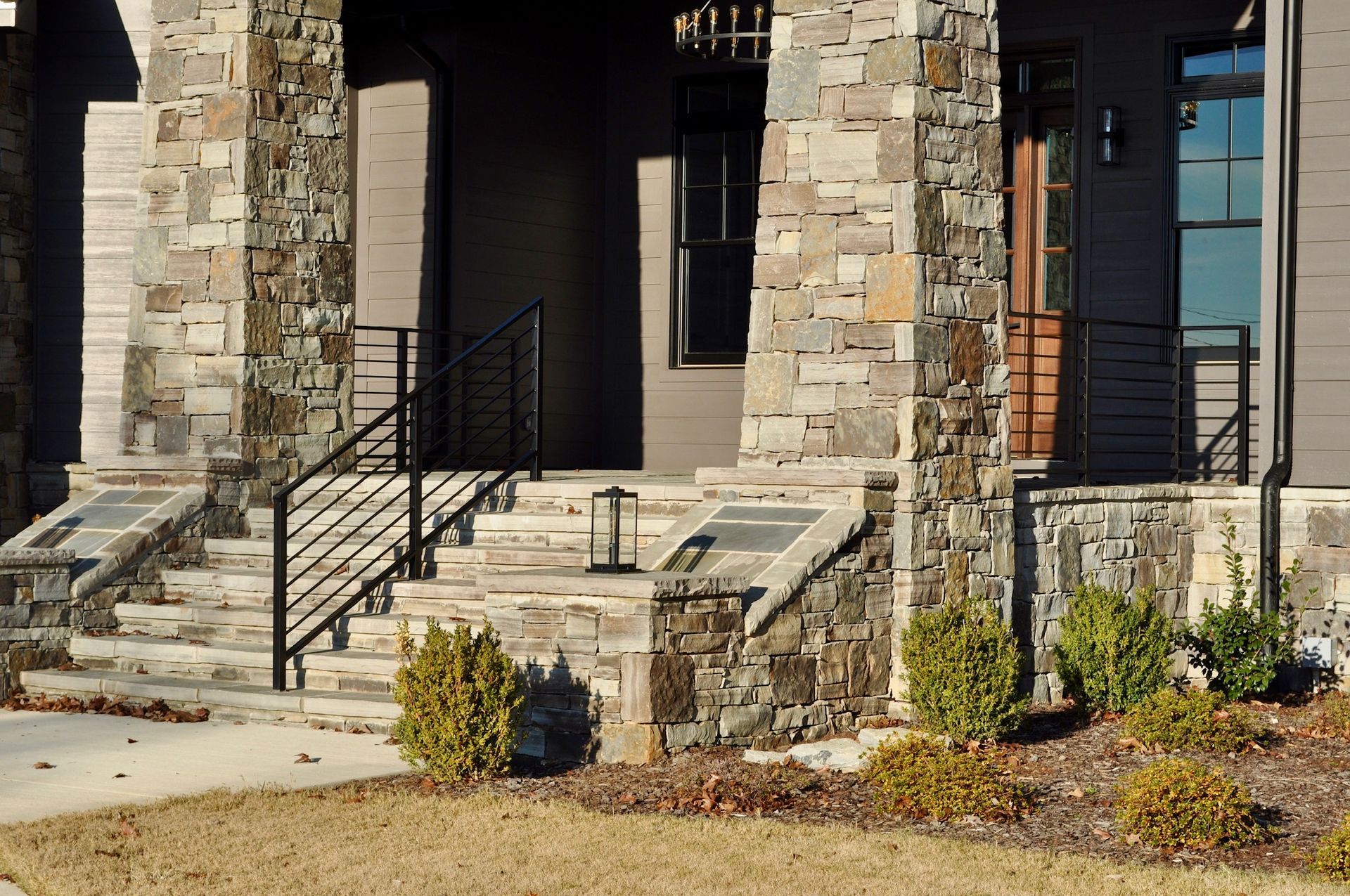 a stone house with stairs leading up to the front door