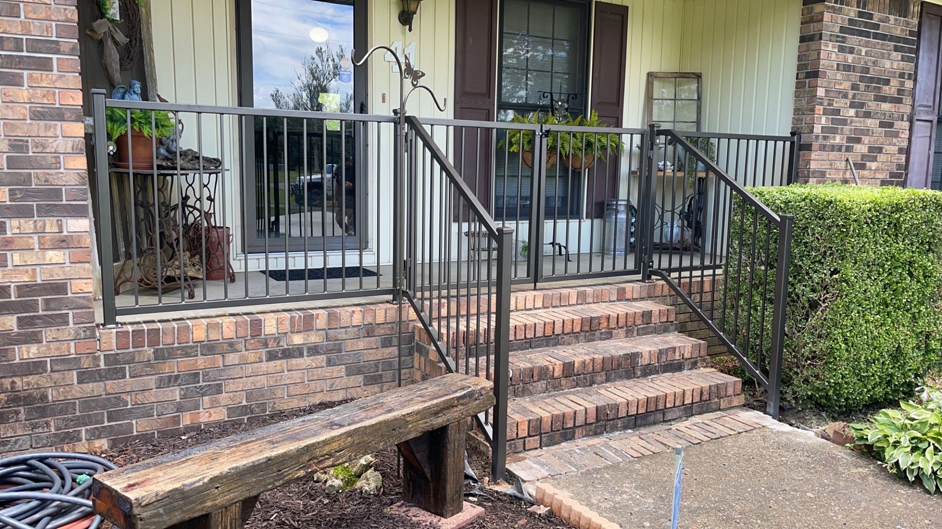 a front porch with a wrought iron railing and stairs leading up to it