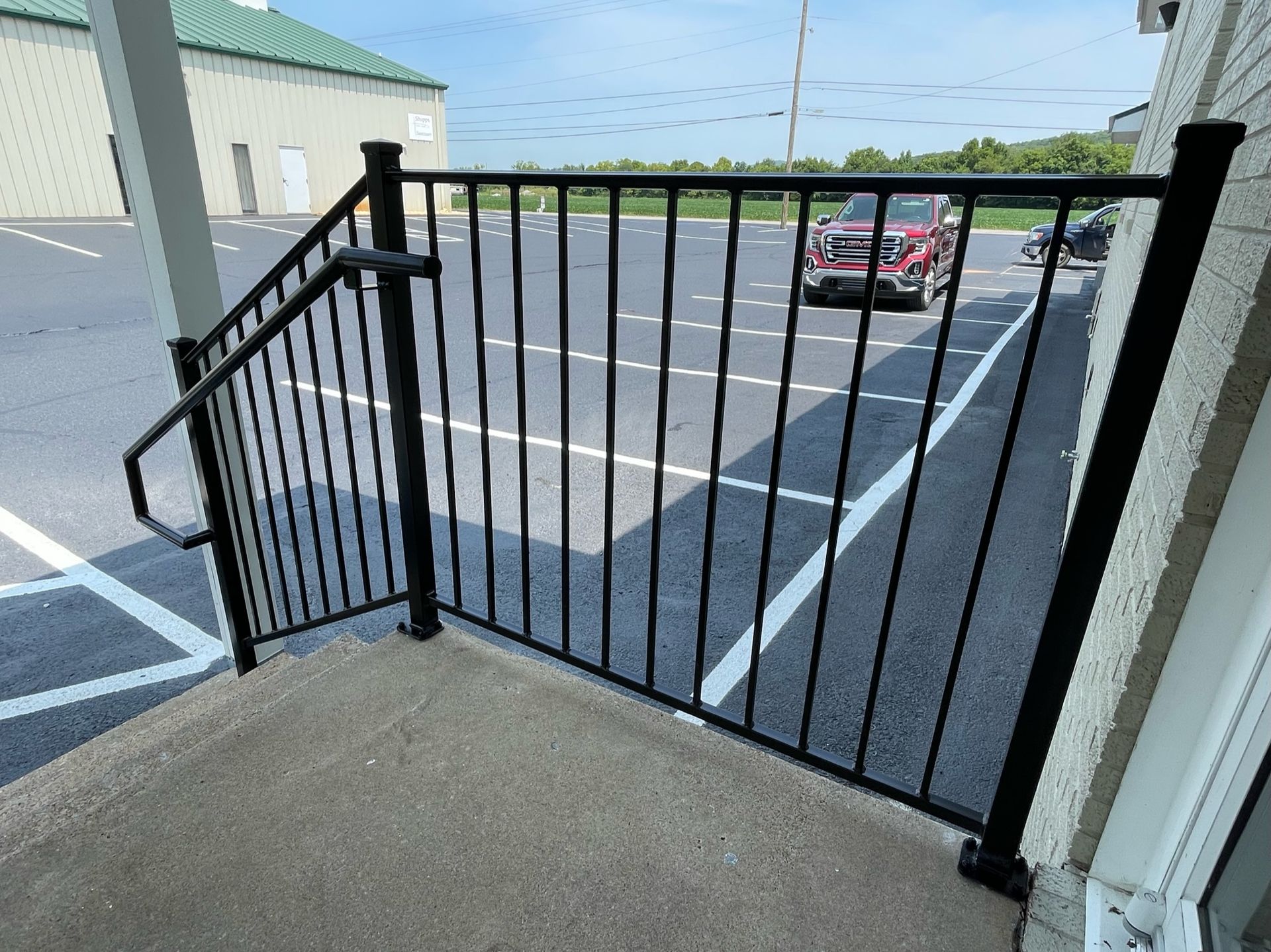 a red jeep is parked in a parking lot behind a black railing