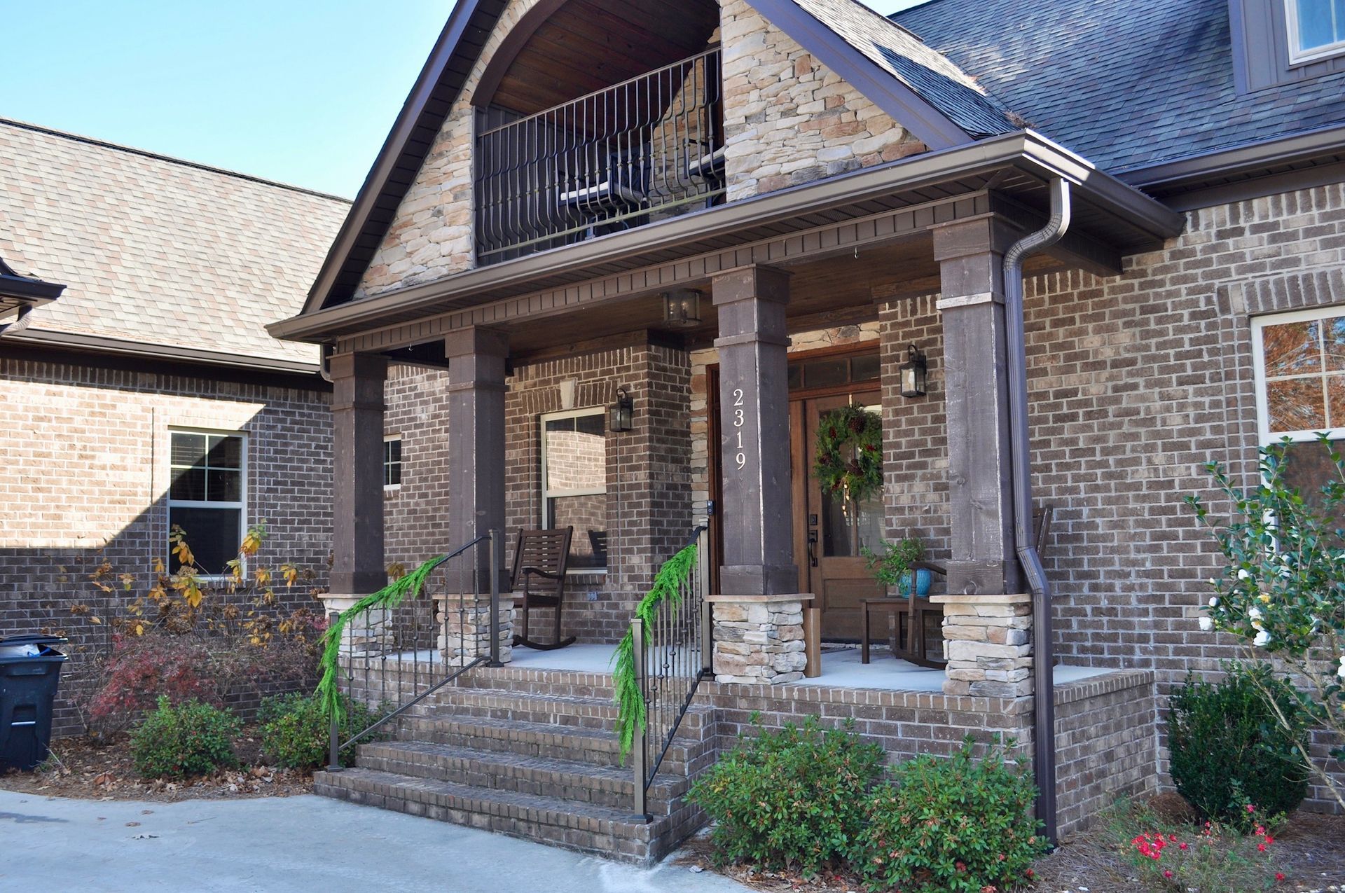 a large brick house with a porch and stairs