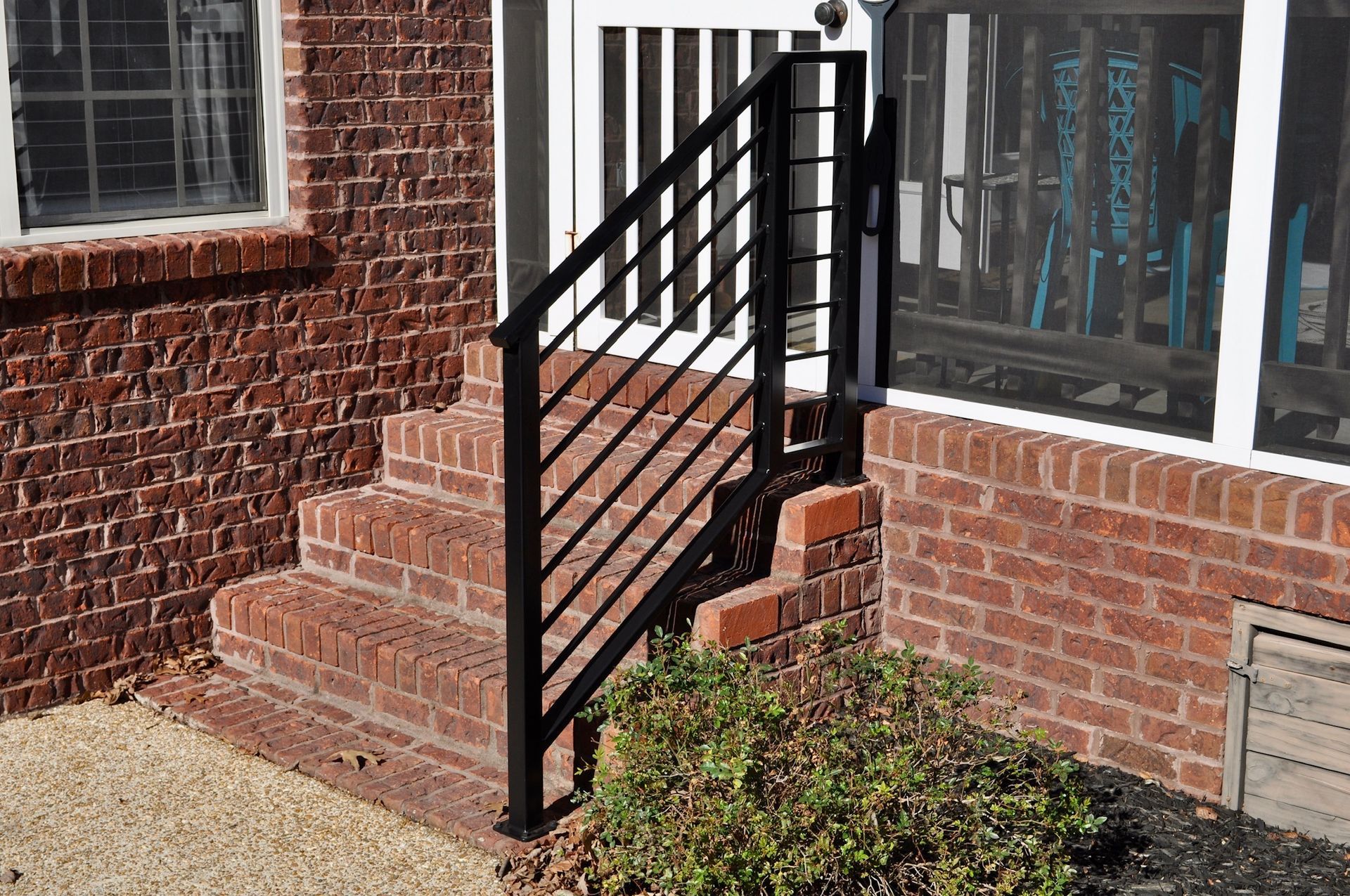 there is a black railing on the side of a brick house