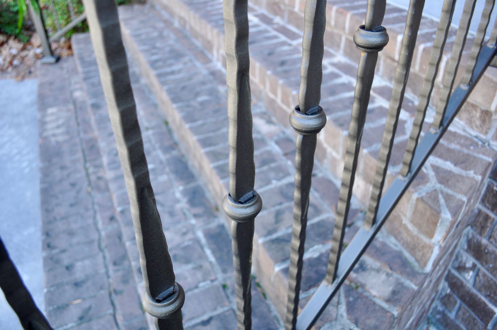 a close up of a wrought iron railing with stairs in the background