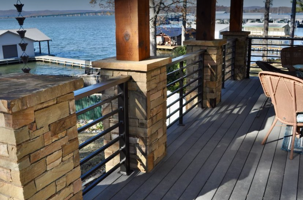 a deck with a railing overlooking a body of water