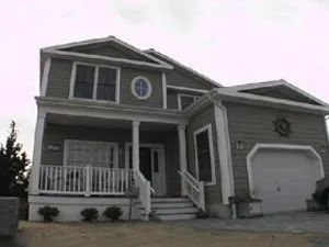 Two-story house with green siding, white trim, and a one-car garage.