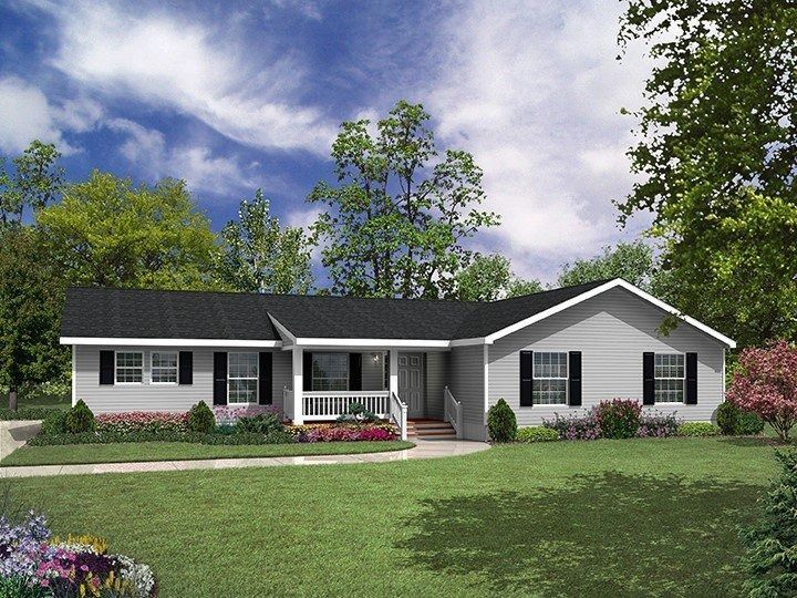 Ranch-style house with gray siding, black shutters, and a porch, set on a green lawn with trees and blue sky.