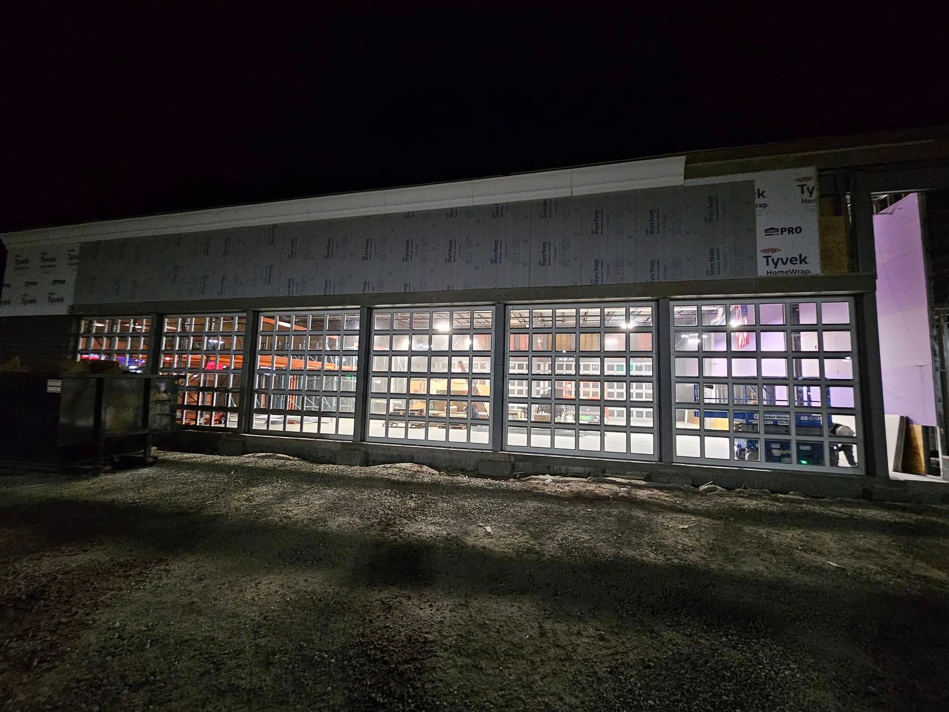 A large building with a lot of windows is lit up at night.