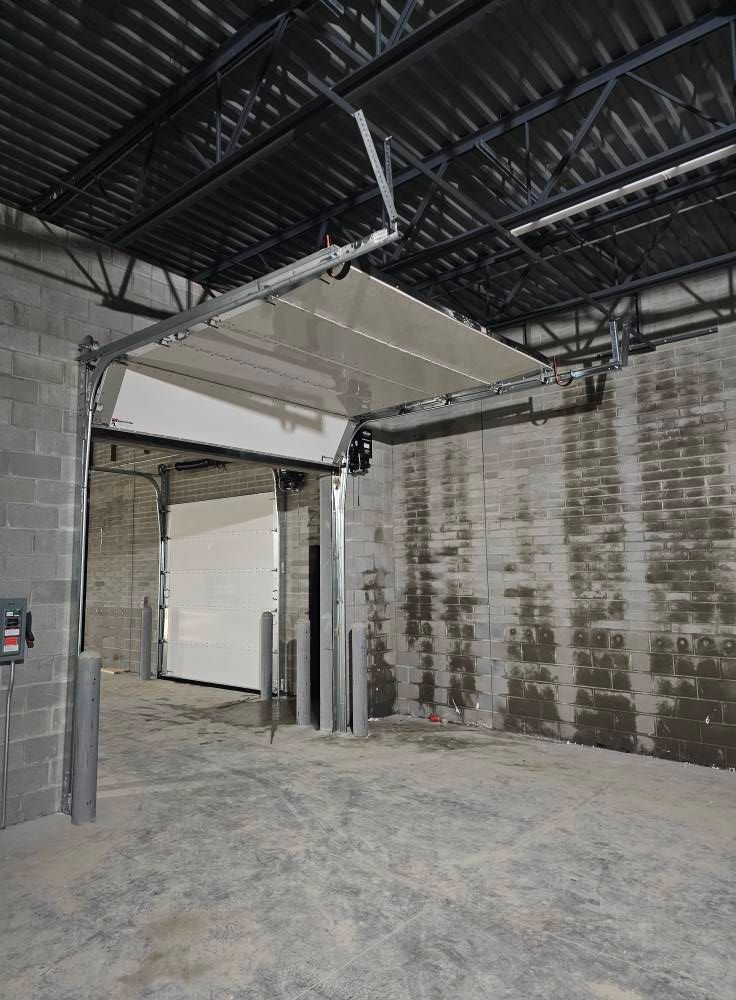 An empty warehouse with a garage door open