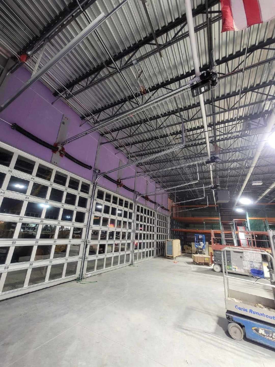 A large warehouse with a lot of doors and a ceiling.