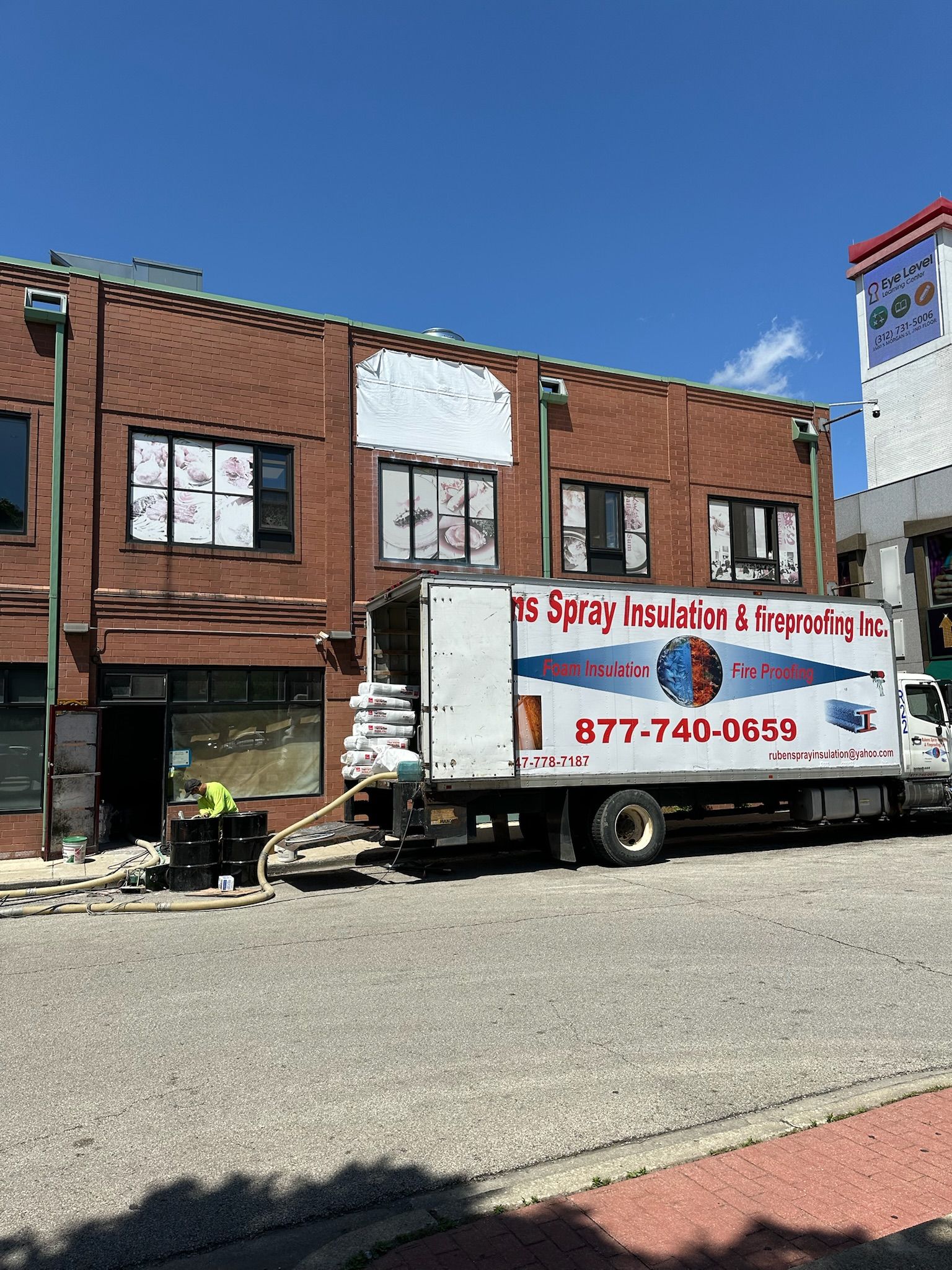A white truck is parked in front of a brick building.