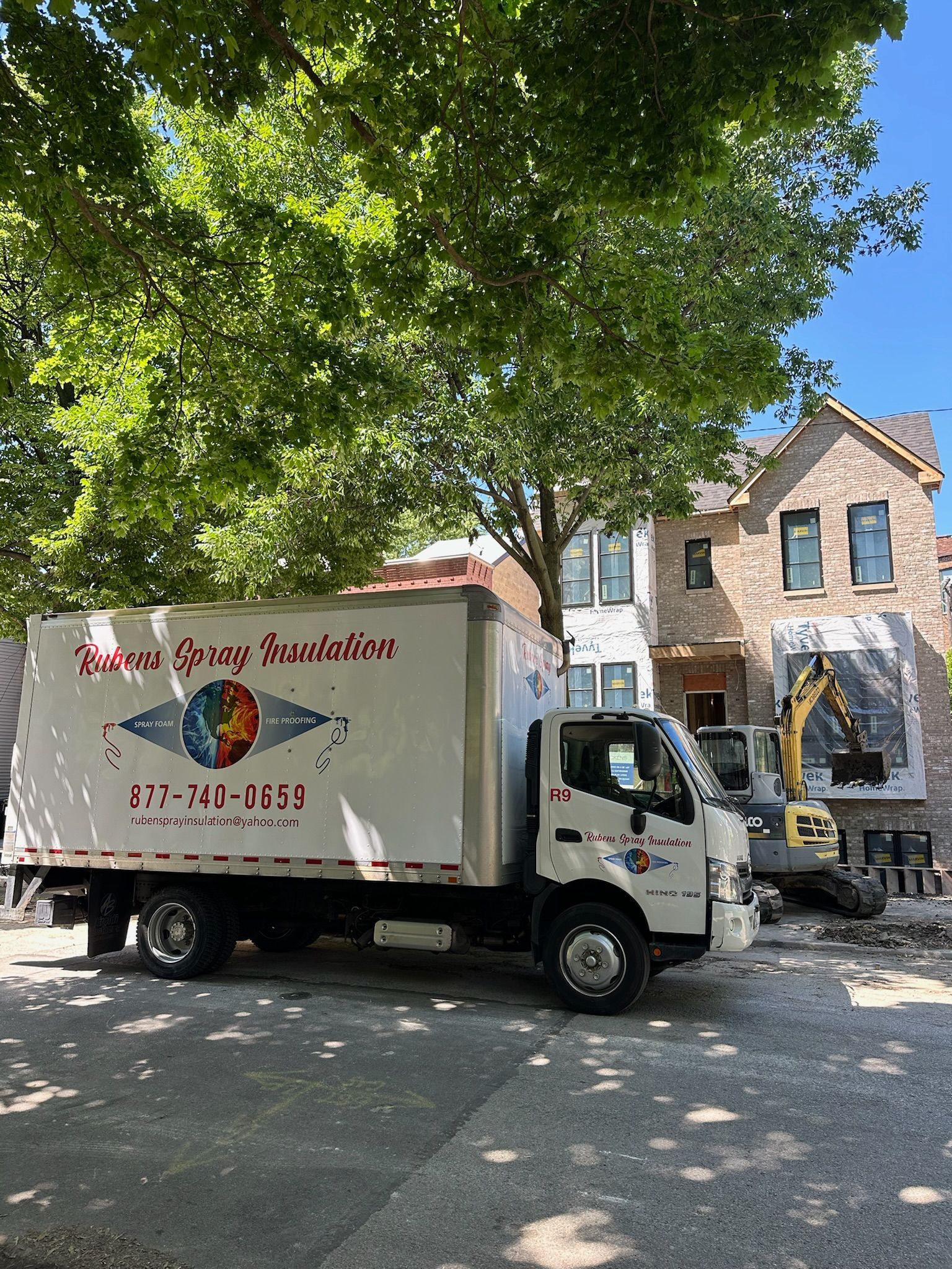 A white truck is parked in front of a brick house.