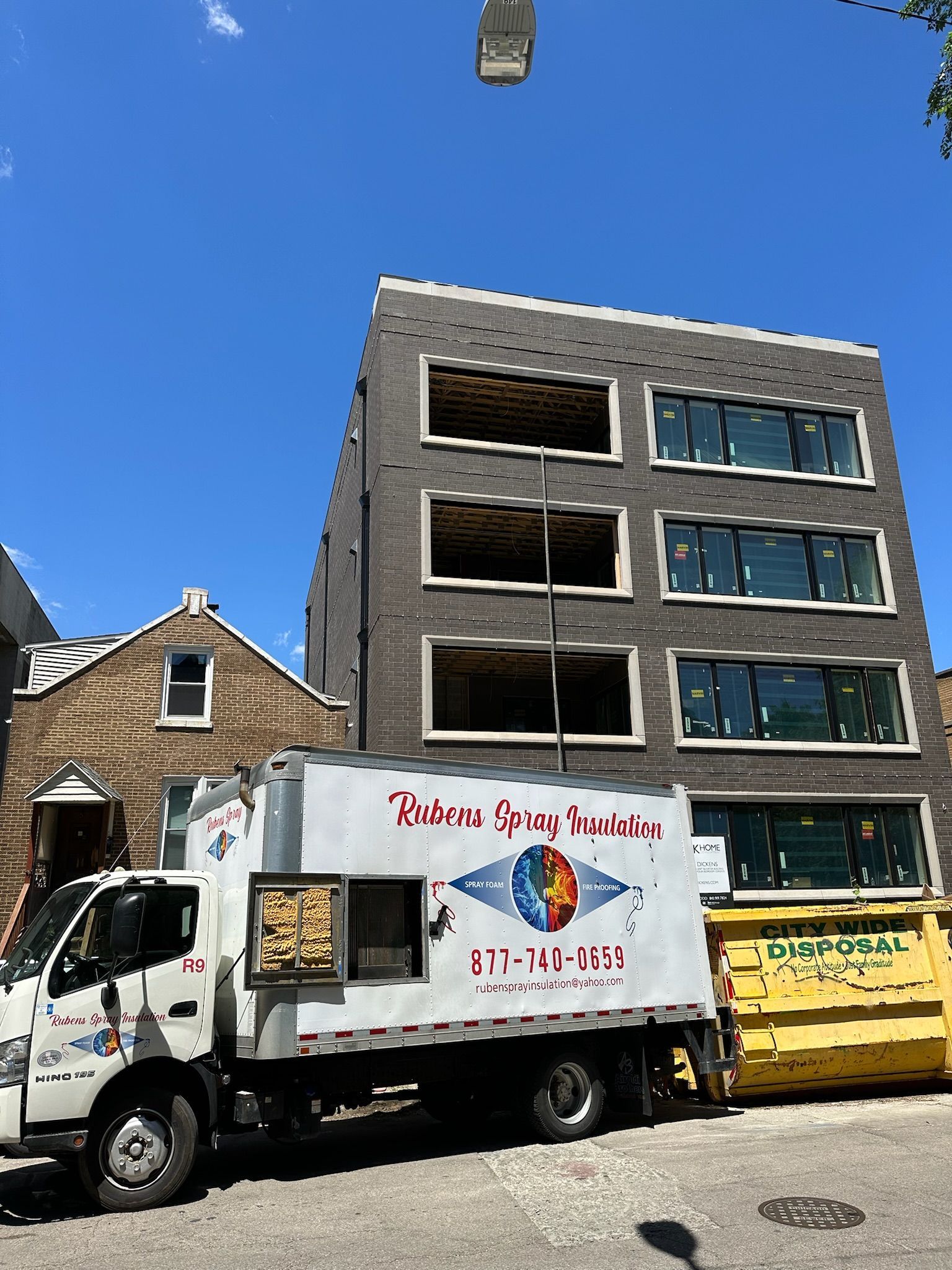 A white truck is parked in front of a building that is under construction