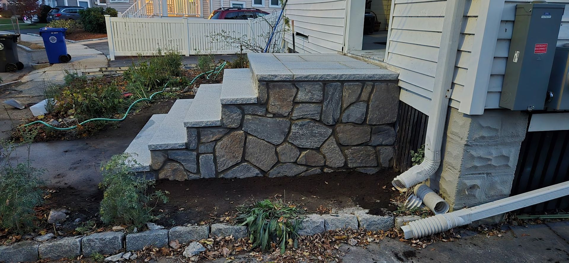 Stone steps leading to a house, with a newly landscaped area.
