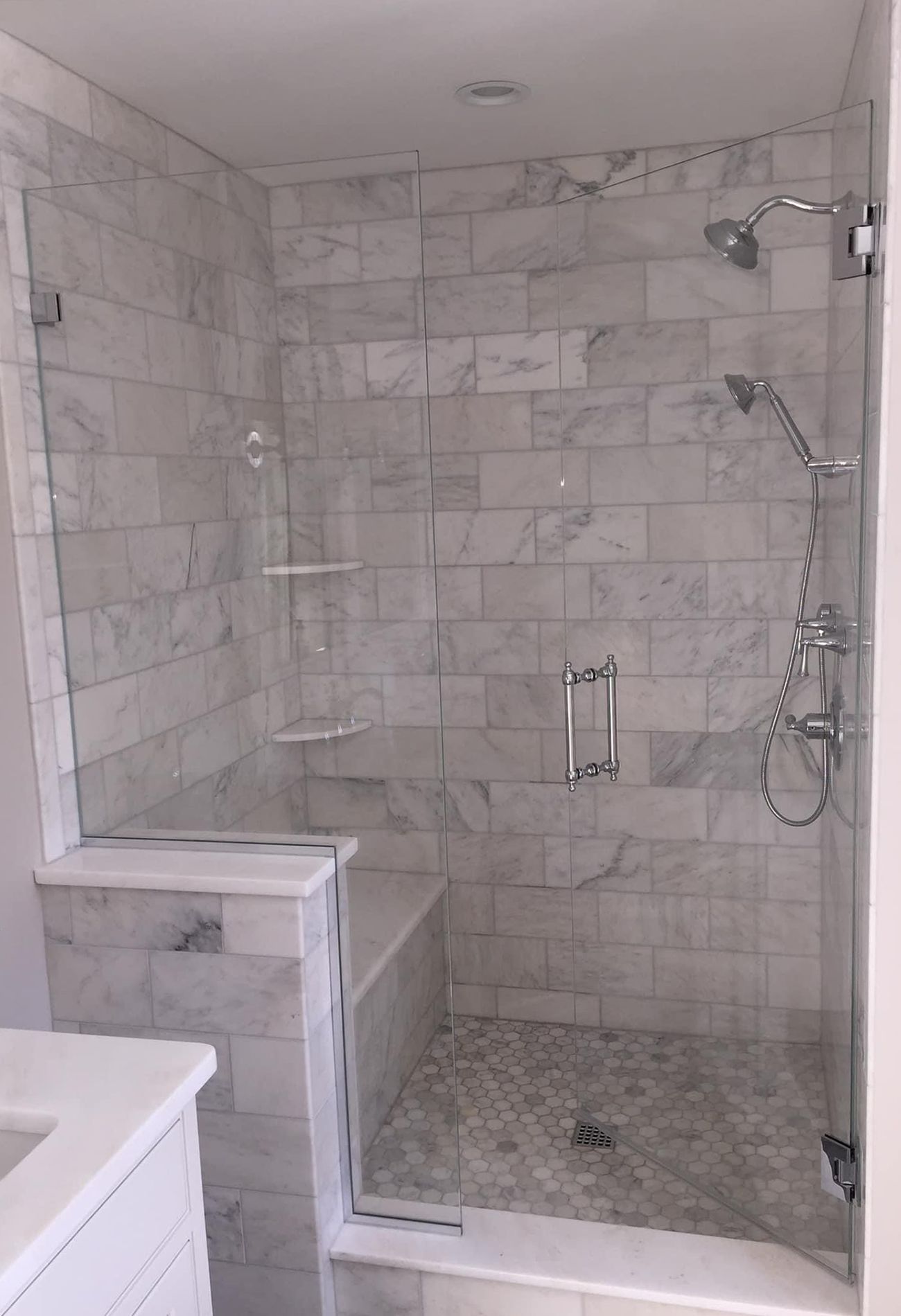 A bathroom with a walk in shower and a sink.