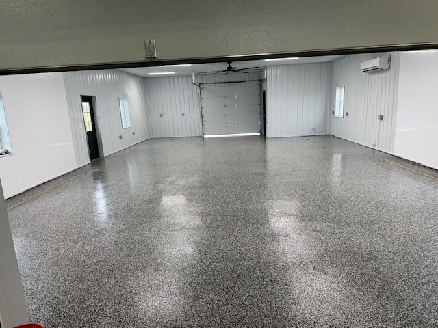Spacious, bright interior of a warehouse-style building with a reflective, speckled epoxy floor.