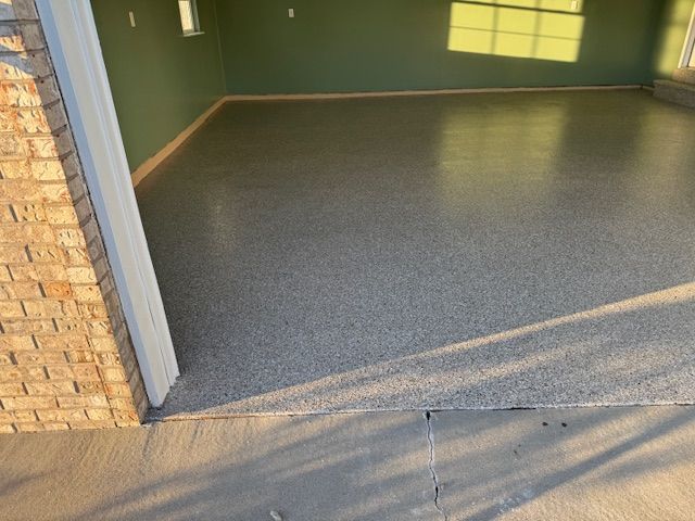 Garage interior with a newly coated speckled gray floor; light green walls.