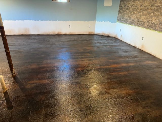Dark stained concrete floor, blue and brown walls, interior construction.