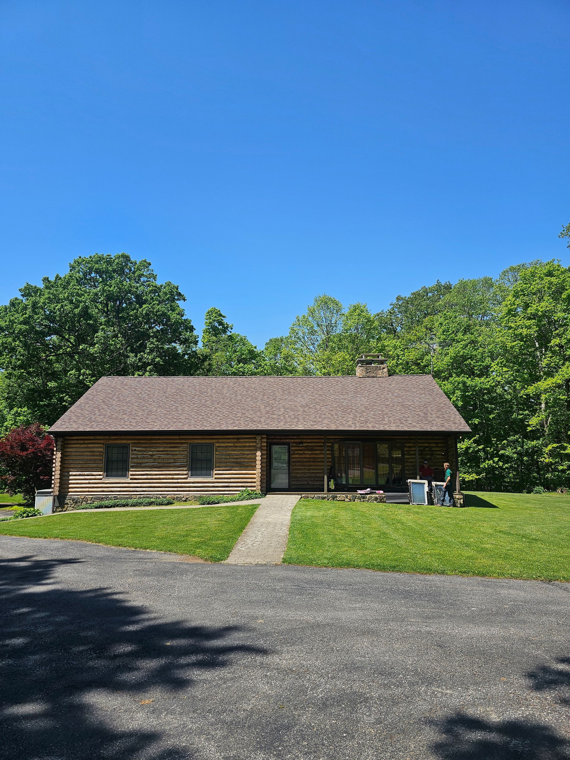 A log cabin is sitting in the middle of a lush green field.