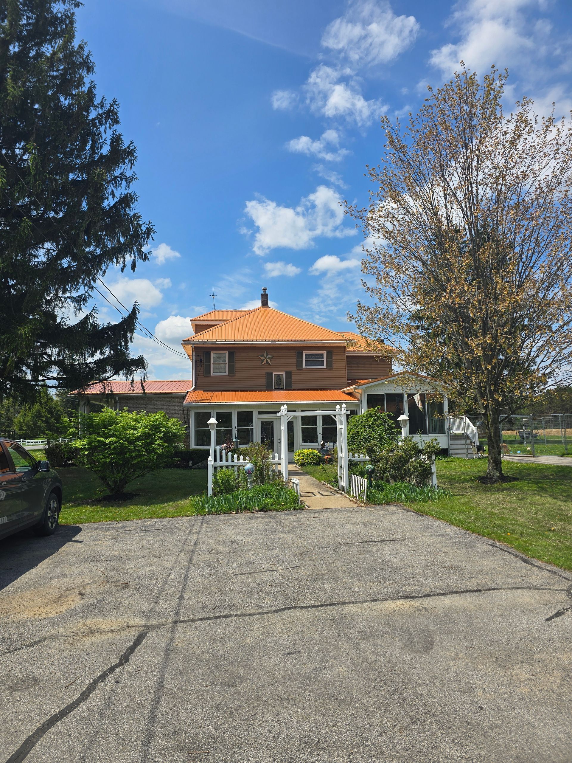A large house with an orange roof and a car parked in front of it