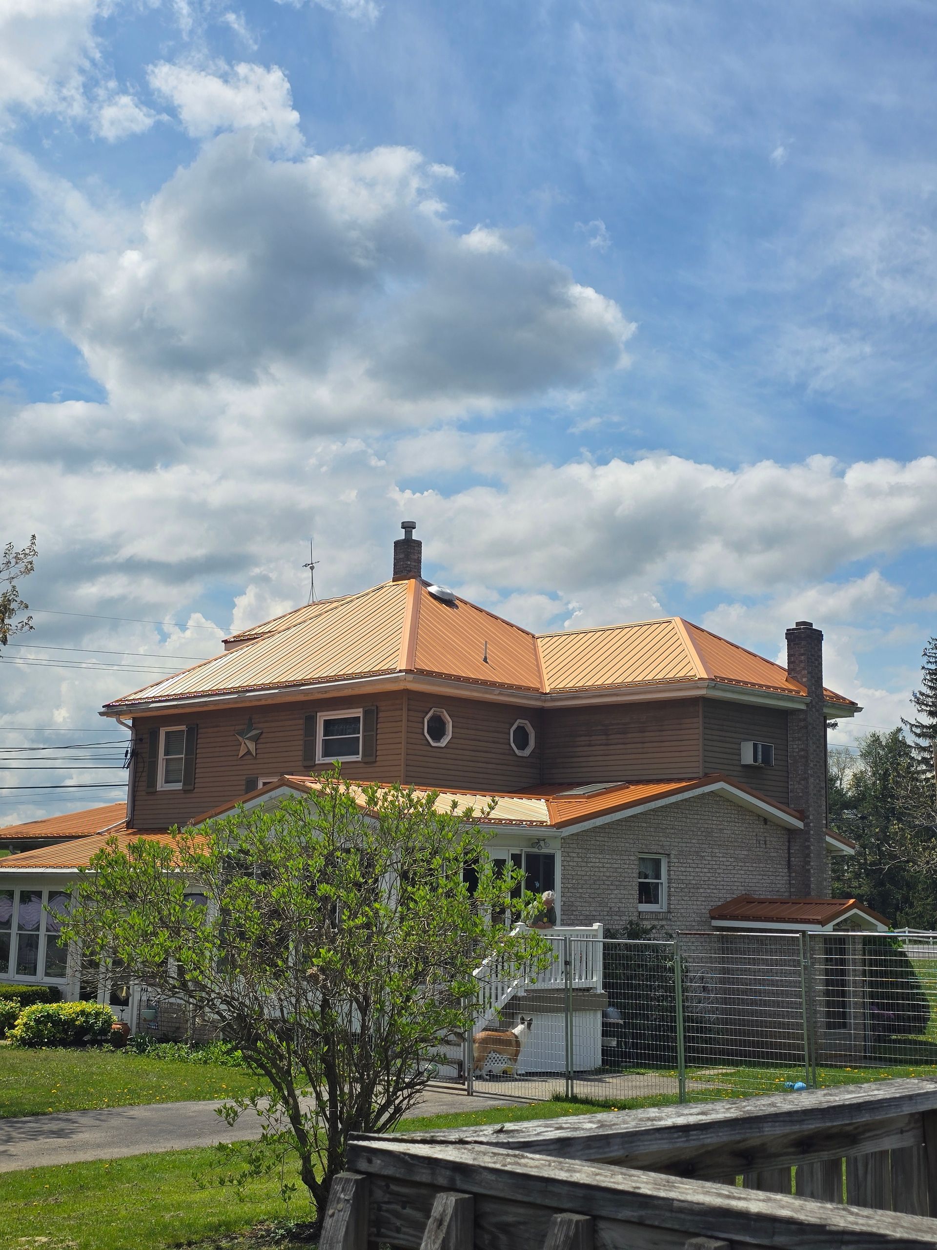 A large house with a wooden roof is under construction.
