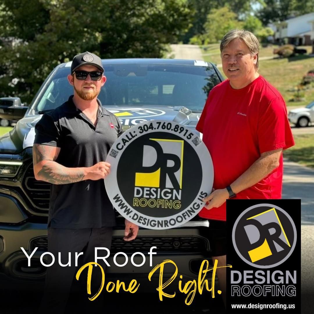 Two men standing in front of a truck holding a sign for Design Roofing. One is wearing a black shirt, the other a red shirt.