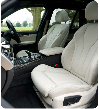 Cream leather car interior with steering wheel, seats, and console.