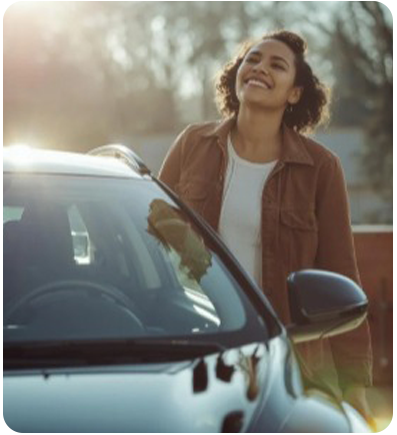 Woman smiling, leaning on a dark car.